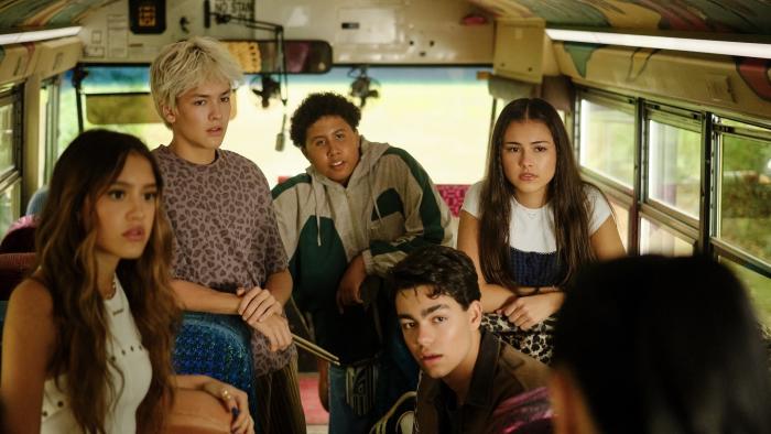Camp Rock 3 Movie: Sage, Desi, Cliff, Rosie and Fletcher sitting on a colorful school bus, looking towards Lark in disbelief.