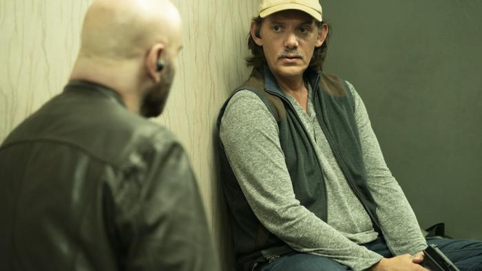 Cash Out Movie: Shawn (Lukas Haas) sits, holding a gun, in serious conversation with Mason, whose back is to viewers