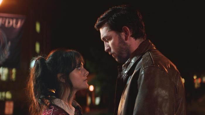 Cat Person Movie: A young White couple looks into each others' eyes while standing outside at night