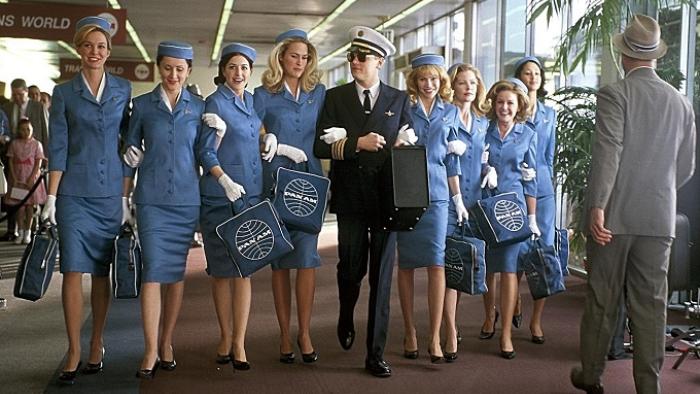 Catch Me If You Can movie: Frank Abagnale Jr. marches arm in arm with a coterie of smiling female flight attendants