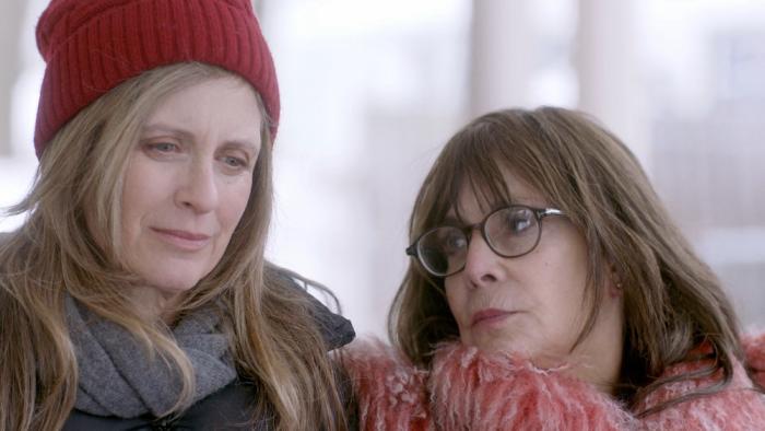 Chantilly Bridge Movie: Helen Slater wears a red beanie and Talia Shire wears a scarf while looking contemplative