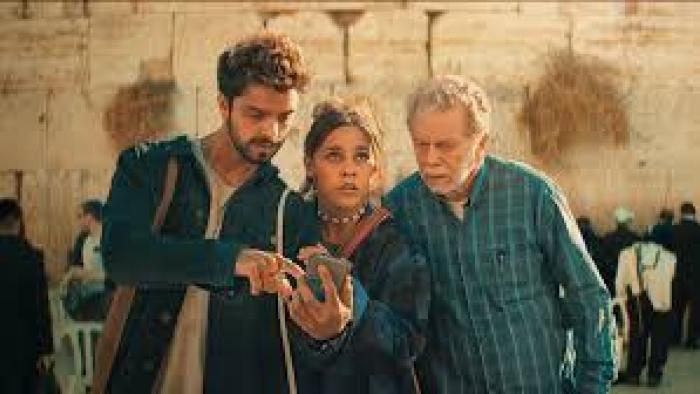 Cheers to Life: Three people look at a phone 