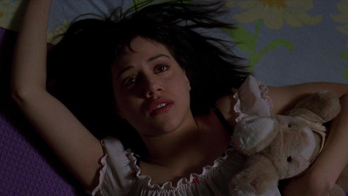 Cherry Falls: A teenage girl lays down on a bed, hugging a stuffed toy