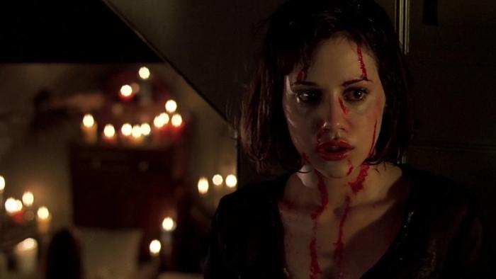 Cherry Falls: A teenage girl is seen with blood running down her face, and candles lighting the darkness behind her