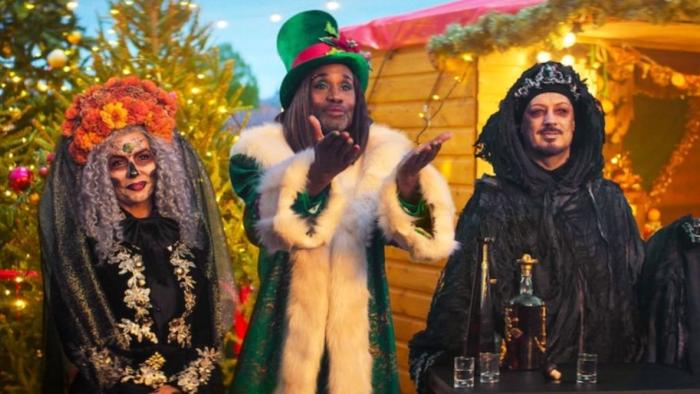 Christmas Karma: Three ghosts in elaborate costumes including Day of the Dead makeup, green fur-trimmed coat with top hat, and black hooded robe