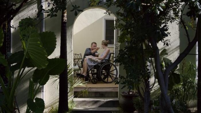 Chronic movie: A White male care-home worker feeds a female patient while she sits in wheelchair