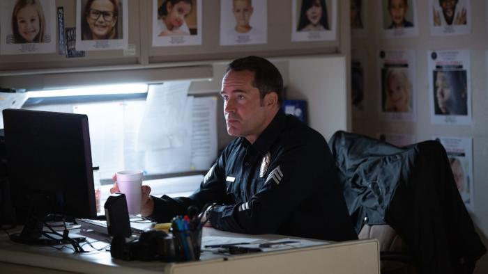 City of Dreams Movie: Police officer Stevens (Jason Patric) sits at his desk surrounded by missing-child fliers