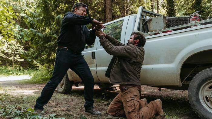Clear Cut Movie: Keen (Tom Welling), standing, fights over a weapon with Jack (Clive Standen), kneeling on the ground