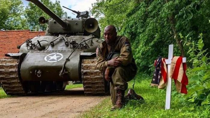 Come Out Fighting Movie: Tyrese Gibson kneels next to an Army tank and a white cross draped with the American flag