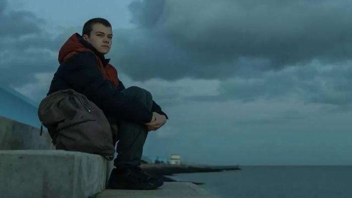 County Lines: A teenage boy sits on a wall overlooking the sea