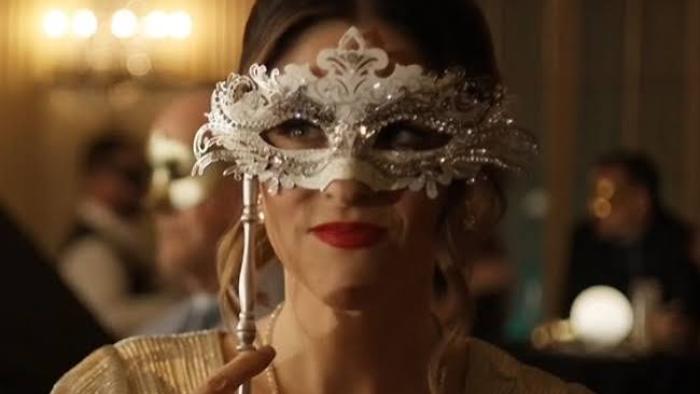 Dancing with a Murderer: Woman in ornate silver mask at elegant event.