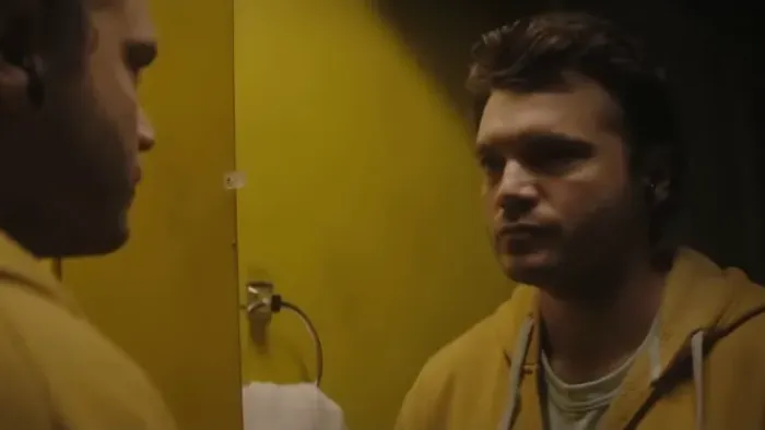 Dead Money movie: Emile Hirsch in yellow hoodie left looks at himself in a mirror