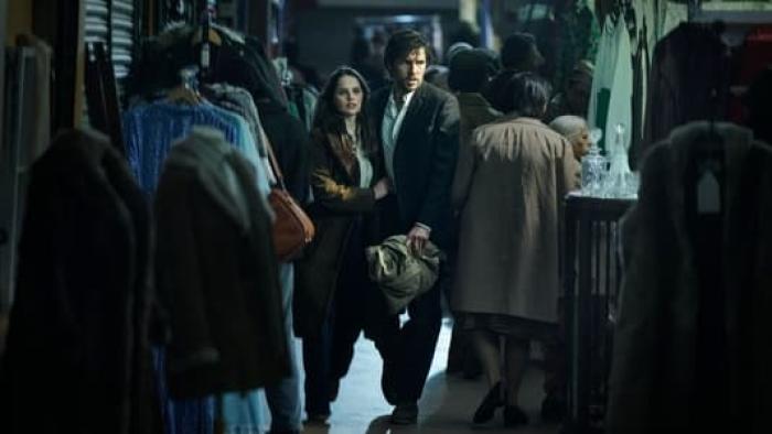 Dead Shot: A young White couple walk through a clothing store close together looking concerned