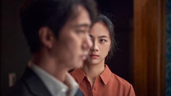 Decision to Leave: A Chinese woman looks at a Korean man in profile