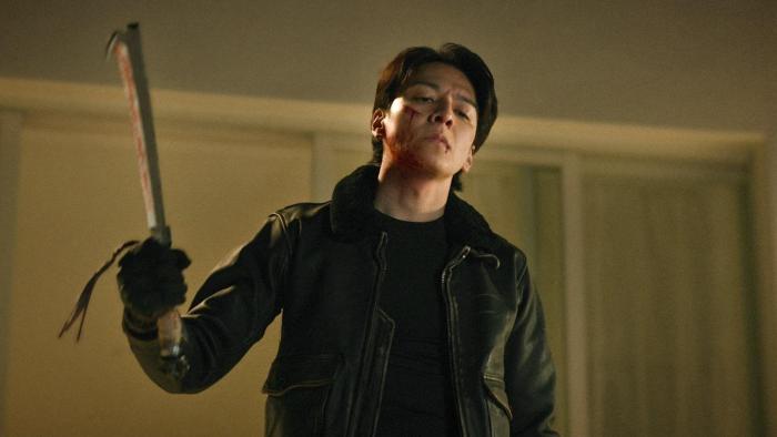 Demon City movie: Japanese man in black leather jacket center raises bloody sword in right hand
