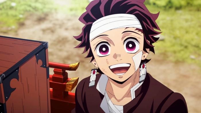 Tanjiro rides on a decorative wooden cart, although he is injured, he expresses excitement at the people cheering him on.