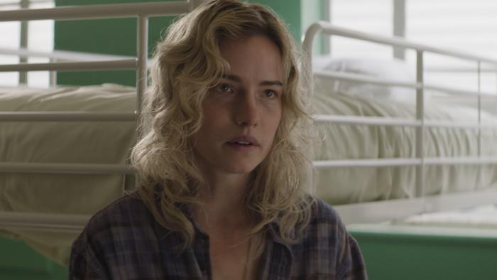 Desperation Road Movie: Maben (Willa Fitzgerald) leans against a white bed, looking concerned