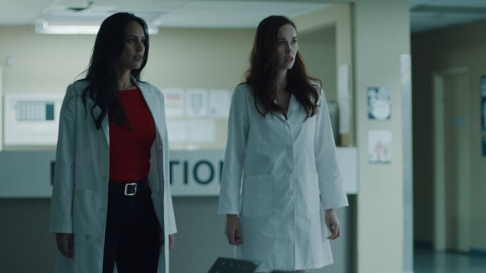 Disquiet Movie: Lily and Monica stand in a hospital reception area, looking scared
