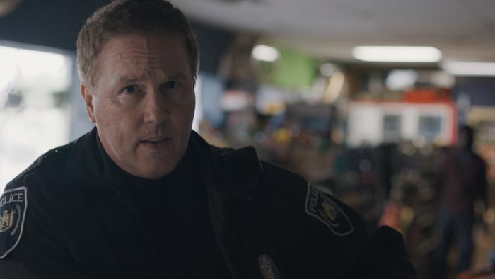 Disquiet Movie: Police officer Frank appears to be at the checkout counter of a convenience store