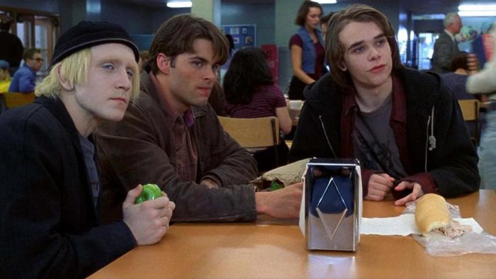 Disturbing Behavior: Three young teen boys sitting at a cafeteria table, holding drinks and food