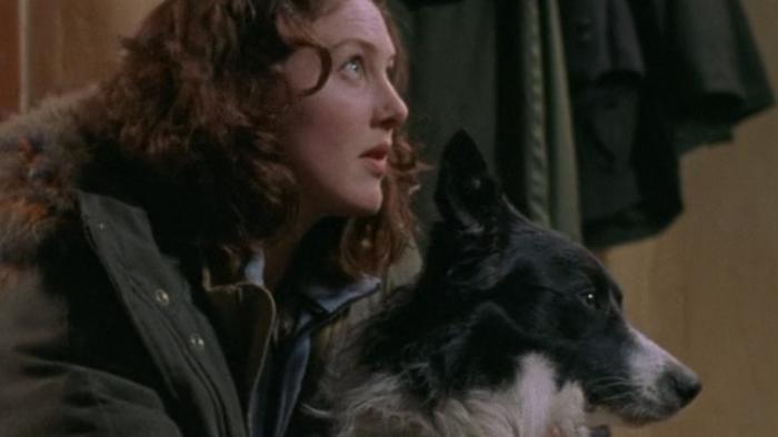 Dog Soldiers: Emma Cleasby crouches with a black and white dog wearing a green coat