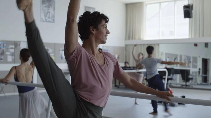 Dreams movie: Isaac Hernandez stands at a ballet barre with his leg raised