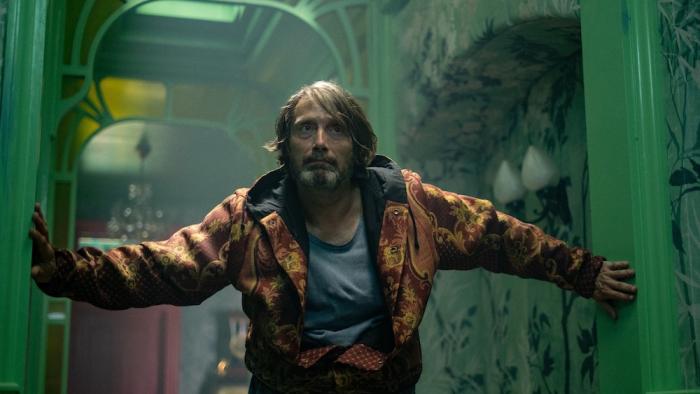 Dust Bunny Movie: The neighbor (Mads Mikkelsen) stumbles down a hallway, bracing himself with the walls
