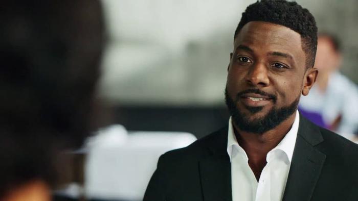 Dutch Movie: Bernard "Dutch" James (Lance Gross) sits across from someone at a restaurant, talking and smiling