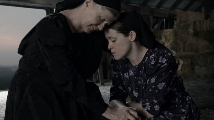 Women Talking: Two women with their heads together, eyes closed