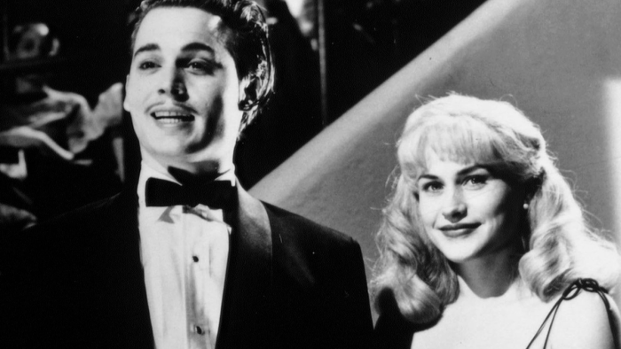 Ed Wood movie: Man and woman in formal black-tie apparel stand in an auditorium