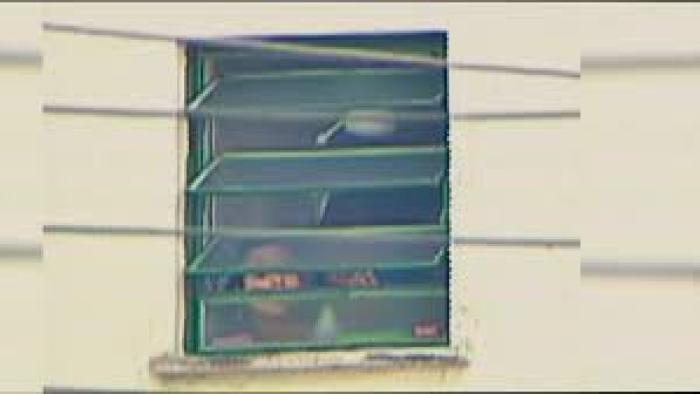 Eloá the Hostage: Live on TV movie: A woman peers out from a window