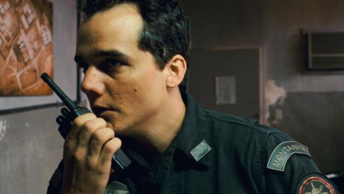 Elite Squad 2 -- The Enemy Within: Officer using a radio in a dimly lit room