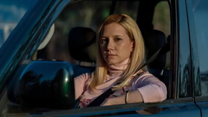 Elize: Shadows of a Woman movie: Woman with blonde hair driving a car, looking forward, wearing a seatbelt.