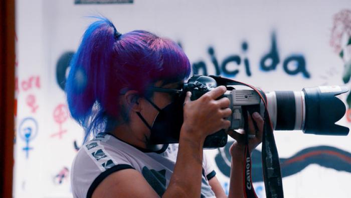 Photojournalist Sáshenka Gutiérrez at work with camera.