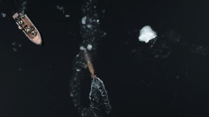 Endurance: Icy dark blue waters with a red ship and submarine device seen from above