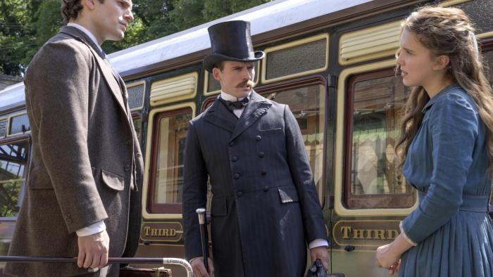 Enola Holmes movie: Enola speaks with her brothers in front of a train on a platform