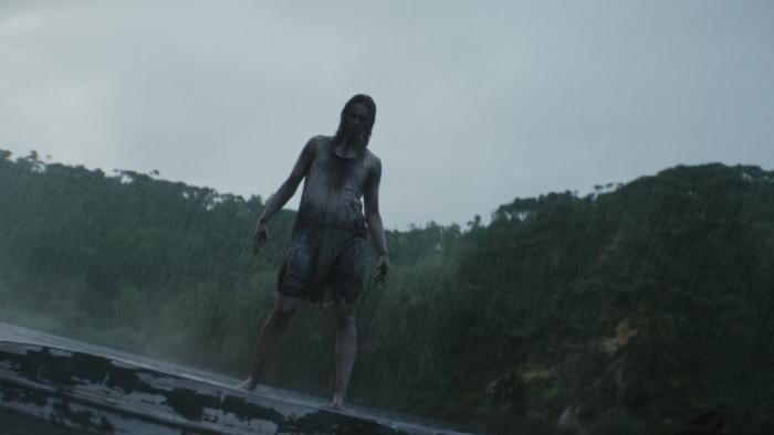 Evil Dead Burn Movie: A deadite in a stained dress stands menacingly on top of an overturned boat