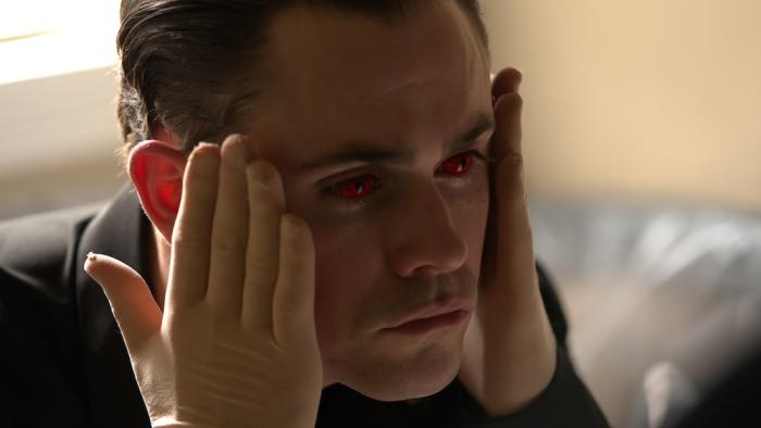 Faces of Death Movie: Killer Arthur (Dacre Montgomery) wears red contact lenses and touches his face with gloved hands