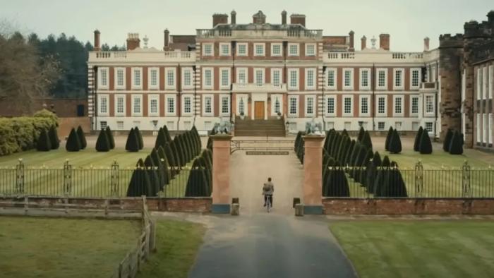 Fackham Hall: A man rides a bicycle through the gates of stately home