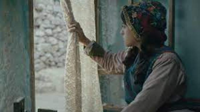 Farha: a girl peers out the window