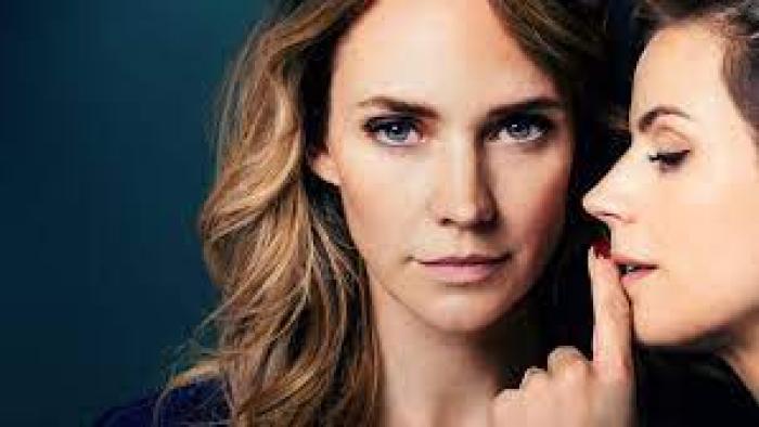 Faithfully Yours: A woman looks ahead while another does a quiet gesture