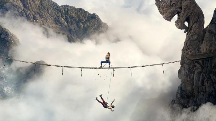 Fall 2: Deadpoint movie: One person is on a plank bridge while another is perilously swinging below it between two mountain summits