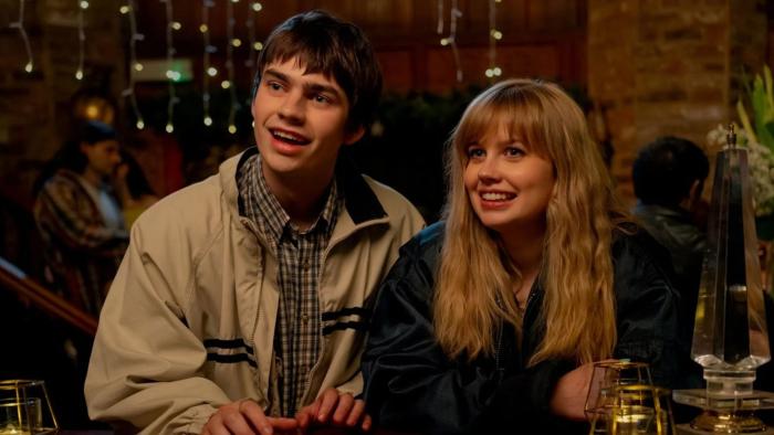 Finding Emily: A young man and woman smiling in a cozy, warmly-lit restaurant