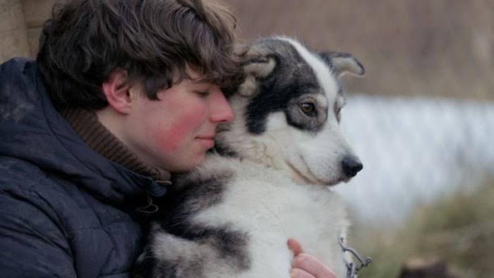 Folktales Movie: Young person hugging a dog outdoors, both looking calm.