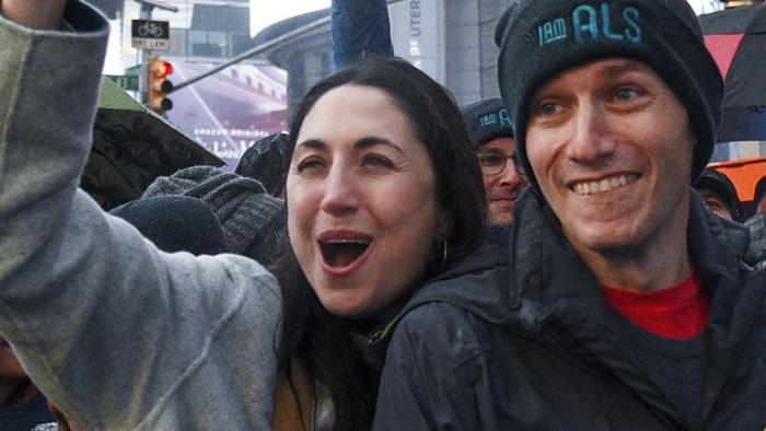 For Love & Life: No Ordinary Campaign movie: white woman center cheers alongside white man with hat that says, "I AM ALS"