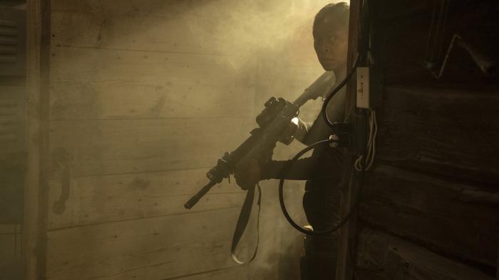 40 Acres Movie: Rifle at the ready, Hailey (Danielle Deadwyler) peers around a doorway into a darkened room