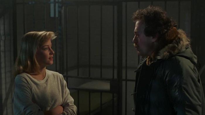 Friday the 13th Part VI -- Jason Lives: Jennifer Cooke and David Kagen look intently at each other, the bars of a jail cell behind them