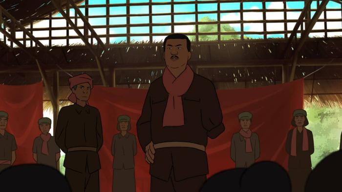 Funan Movie: A mustached official in a red scarf addresses a group