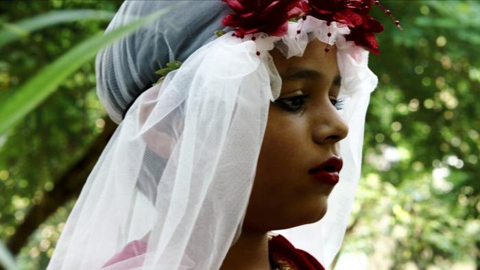 Funny Boy Movie: Arjie wears lipstick and a bridal veil among lush foliage