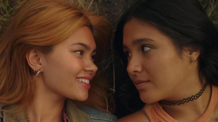 Girls Like Girls movie: Two young women lie on grass, smiling and gazing at each other tenderly